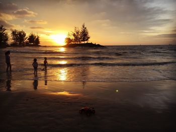 Silhouette people at beach during sunset
