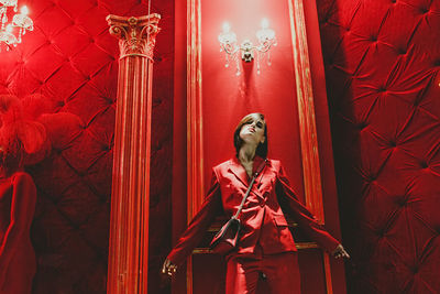 Low angle view of man standing on red ceiling