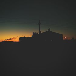 Silhouette buildings against sky at sunset