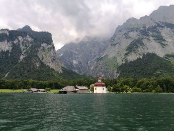 Scenic view of lake by buildings against mountains