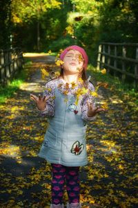 Happy girl standing against plants