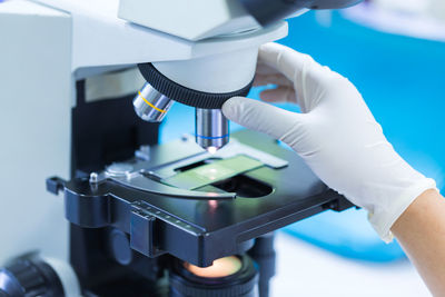 Cropped hands of person on microscope