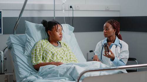 Female doctor discussing over medicine with patient at hospital