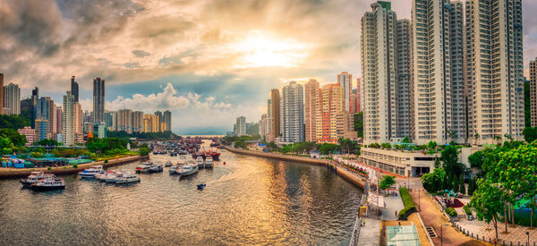 View of river amidst buildings in city against sky