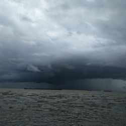 Scenic view of sea against storm clouds