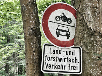 Close-up of warning sign on tree trunk