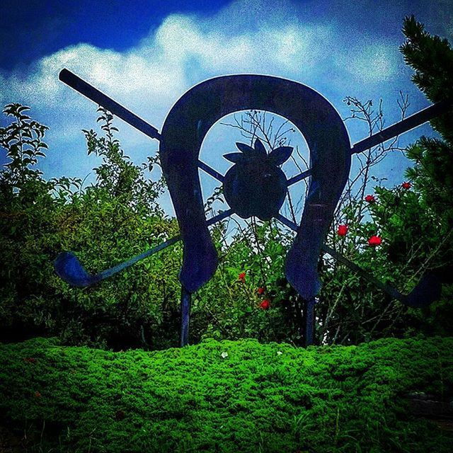 tree, sky, human representation, grass, sculpture, art and craft, art, growth, sunlight, creativity, cloud - sky, field, park - man made space, plant, low angle view, nature, cloud, day, statue