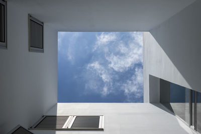 Directly below shot of buildings against blue sky