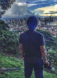 Rear view of man looking at city buildings