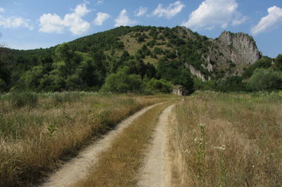 Scenic view of road amidst land against sky