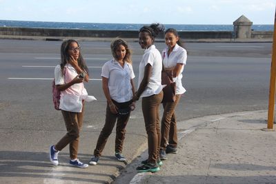 Rear view of people standing on road