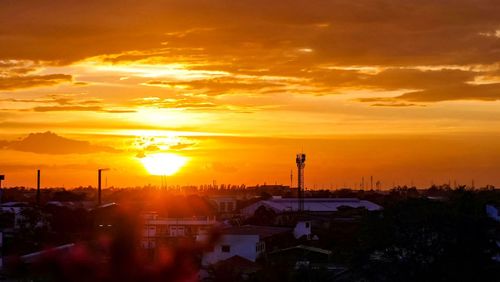Silhouette buildings against sky during sunset