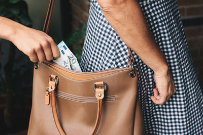 Thief removing paper currency from bag