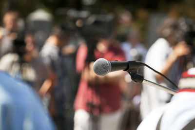 Close-up of microphone against journalists