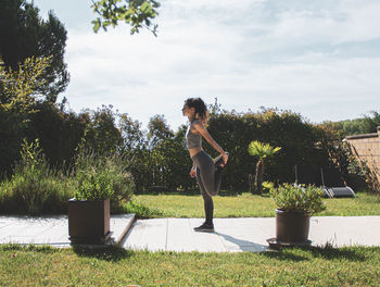 Woman standing by plants against sky