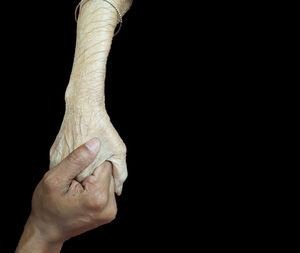 Close-up of man hand against black background