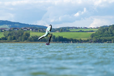 Woman wing foiling on lake wallersee, salzburg, austria.