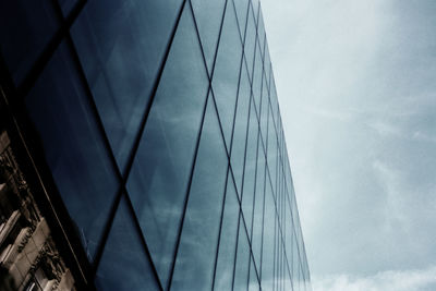 Low angle view of skyscraper against cloudy sky