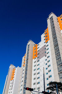 Low angle view of modern buildings against blue sky