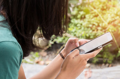 Midsection of woman using smart phone outdoors