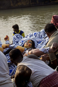 Rear view of people sitting on boat in sea