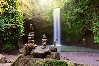 Statue amidst rocks in forest