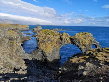 Panoramic view of rocks on sea shore against sky