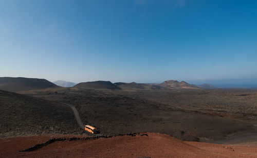 Scenic view of desert against clear blue sky