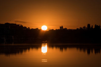 Scenic view of lake against orange sky