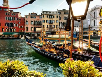 Gondolas on canal against buildings in city