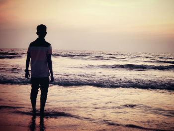 Rear view of silhouette woman standing on beach