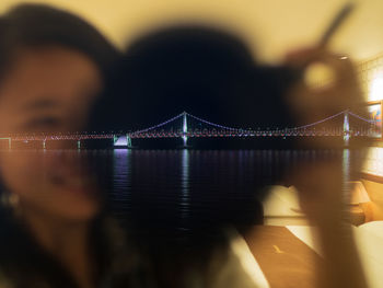 View of suspension bridge in city at night