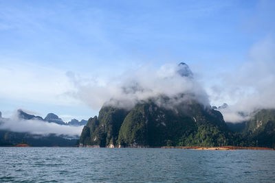 Scenic view of sea and mountains against sky