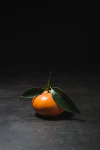 Fresh mandarin with leaves on dark background