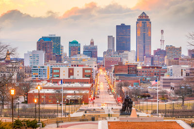 Modern buildings in city against sky during sunset