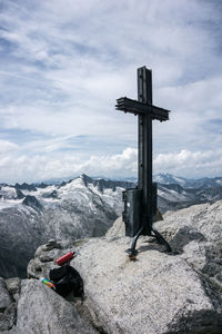 Cross on rock against sky