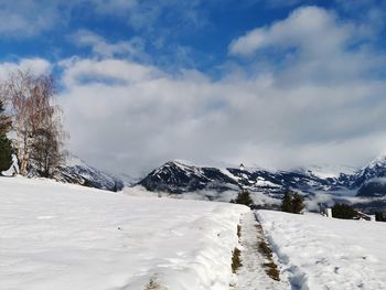 Snow covered landscape against sky