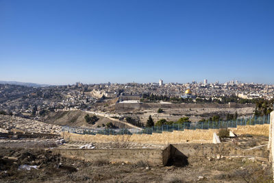 Panoramic view of buildings in city against clear blue sky