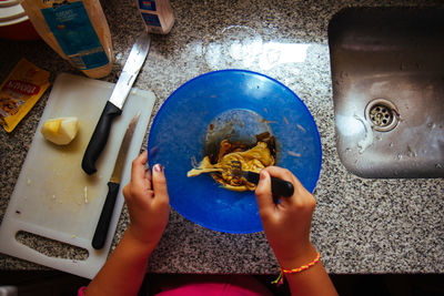 High angle view of person preparing food on bowl.