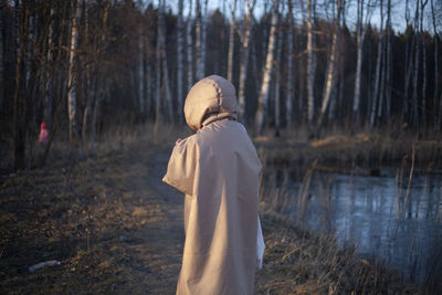 Rear view of woman standing in forest