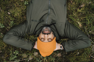 Directly above shot of man lying down on land in forest