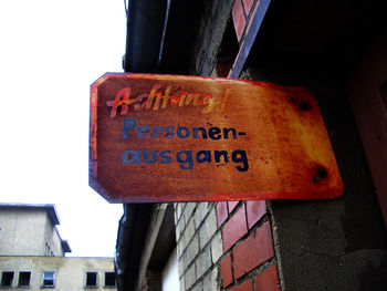 Low angle view of information sign hanging on building