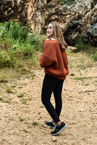 Full length portrait of young woman standing outdoors