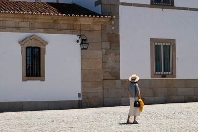 Full length of man standing by house against building