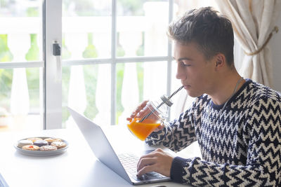 Midsection of man using mobile phone while sitting on table