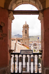 Buildings against sky seen through arch window