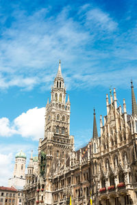 Low angle view of new town hall and frauenkirche against sky