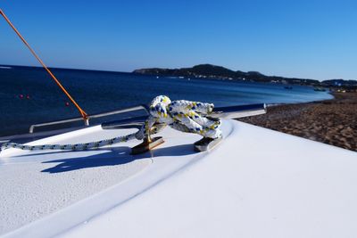 Deck chairs on beach against clear blue sky