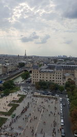 High angle view of crowd on street against cloudy sky