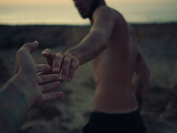 Close-up of hands holding water at beach